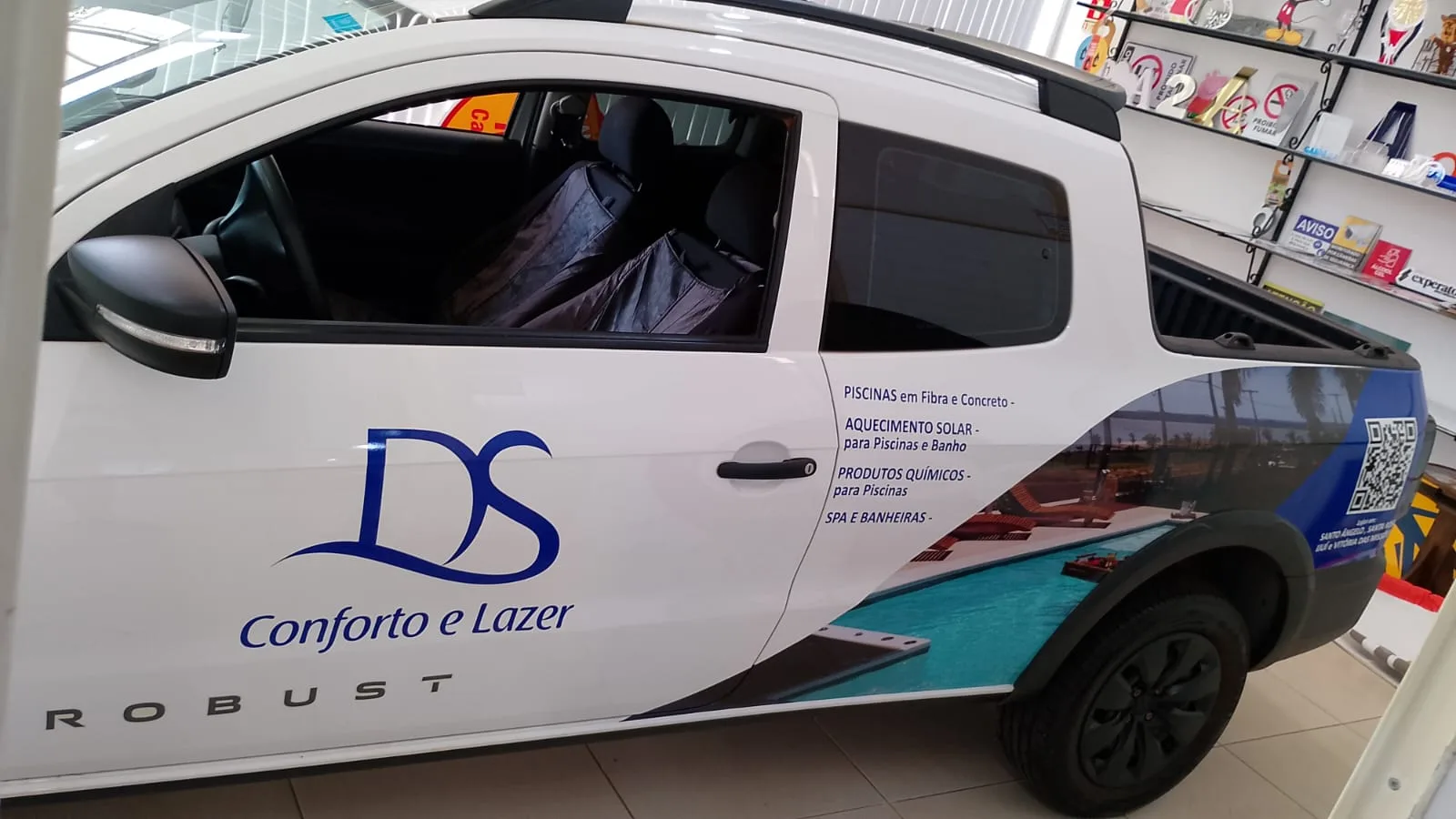 Lateral de picape branca com logotipo da DS Conforto e Lazer e adesivo impresso com foto de piscina