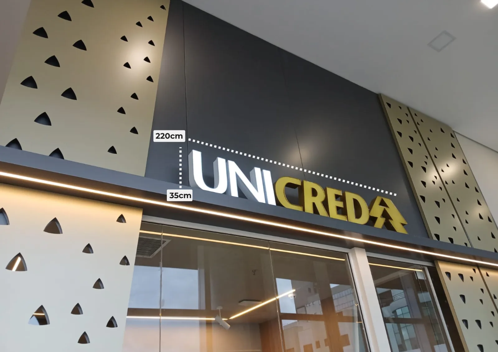 Fachada da Unicred com letra caixa luminosa em branco e dourado, medindo 220 por 35 centímetros