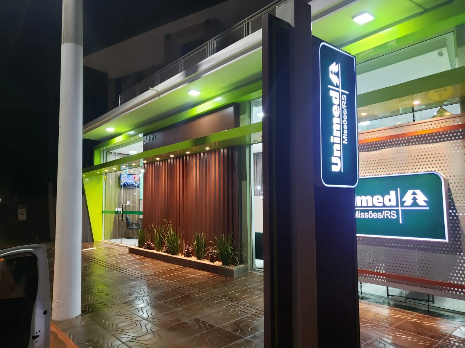 Totem luminoso da Unimed Missões/RS aceso à noite em frente à unidade